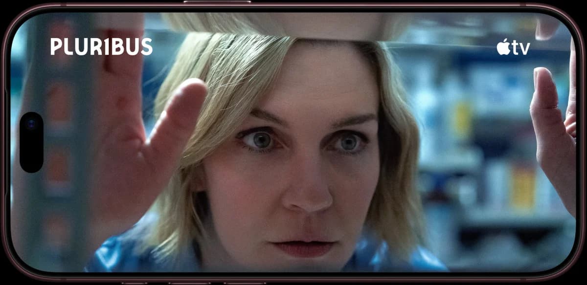 Apple iPhone 18 Pro: Celular bordô na horizontal exibindo cena de série com o rosto de uma mulher loira e o logo Apple TV