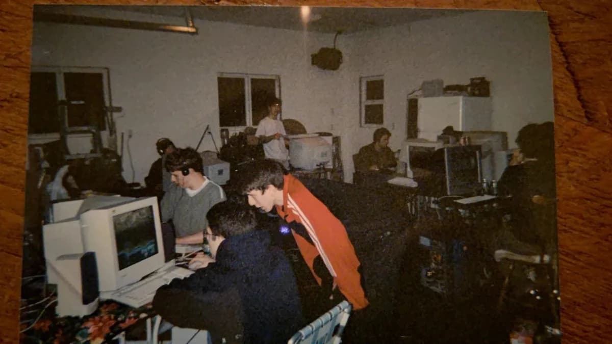 Lan house anos 2000, cybercafé com computadores de mesa e monitores CRT: Foto antiga de sala com várias pessoas em computadores de mesa com monitores CRT, em am