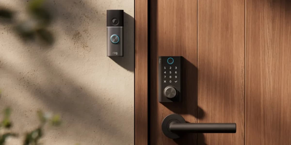 Ring Smart Lock: Fechadura inteligente preta com teclado numérico e campainha com câmera ao lado, instaladas em porta de madeira e parede bege