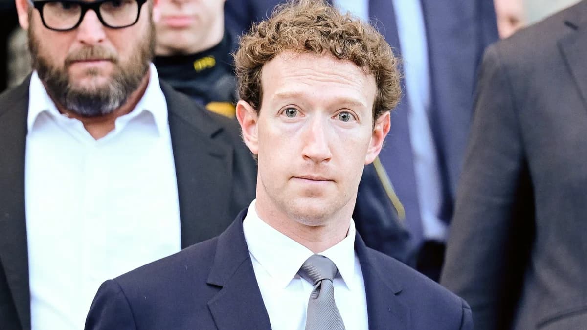 Meta, Facebook, processo de privacidade no Novo México: Homem de terno escuro e gravata cinza saindo de um prédio, cercado por seguranças, olhar sério para a câ