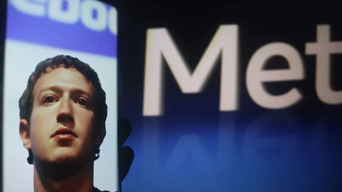 Meta Meta, Facebook, processo de privacidade no Novo México: Rosto de homem projetado em tela ao lado de letras 'Meta' brilhantes em fundo escuro, durante event