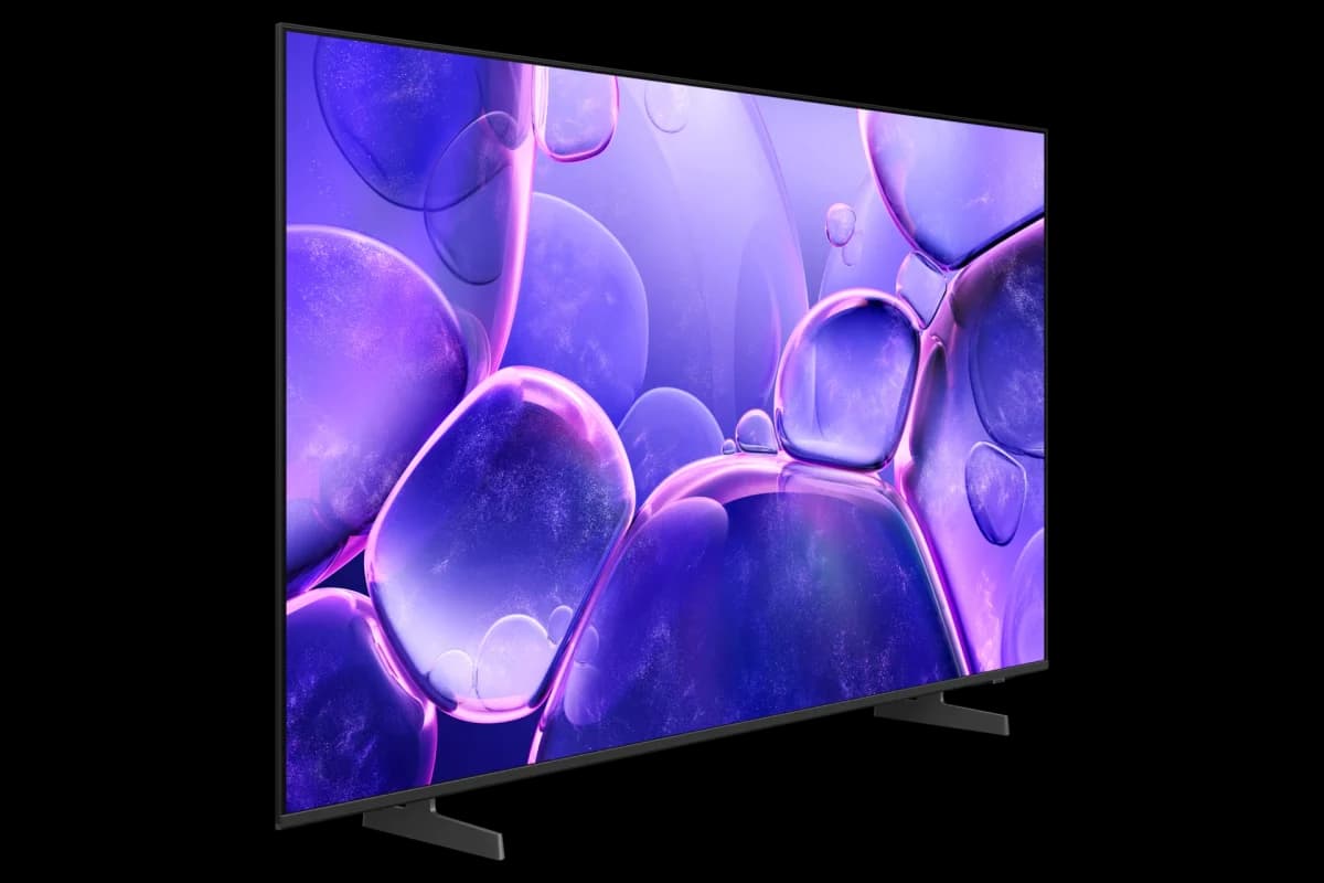 Samsung TV: TV de tela plana vista em ângulo lateral, com imagem roxa de bolhas abstratas na tela e base em formato de pés pretos.