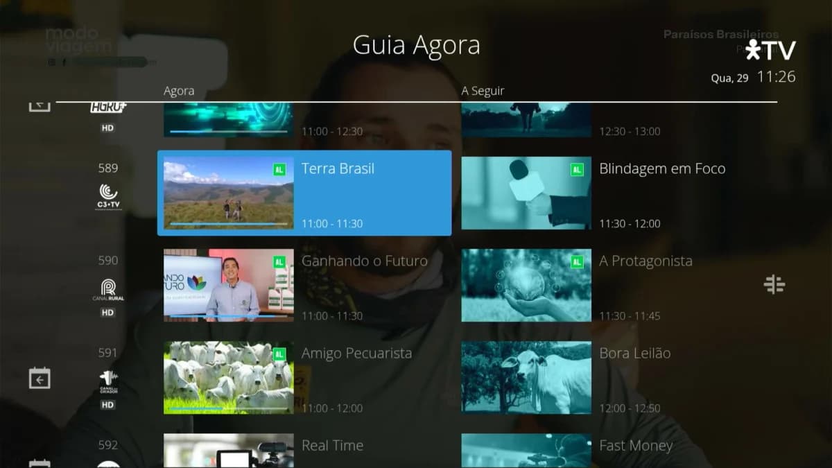 TV por assinatura e TV online: Captura de tela do "Guia Agora" de TV com lista de programas por horário e numeração de canais sobre fundo escurecido.