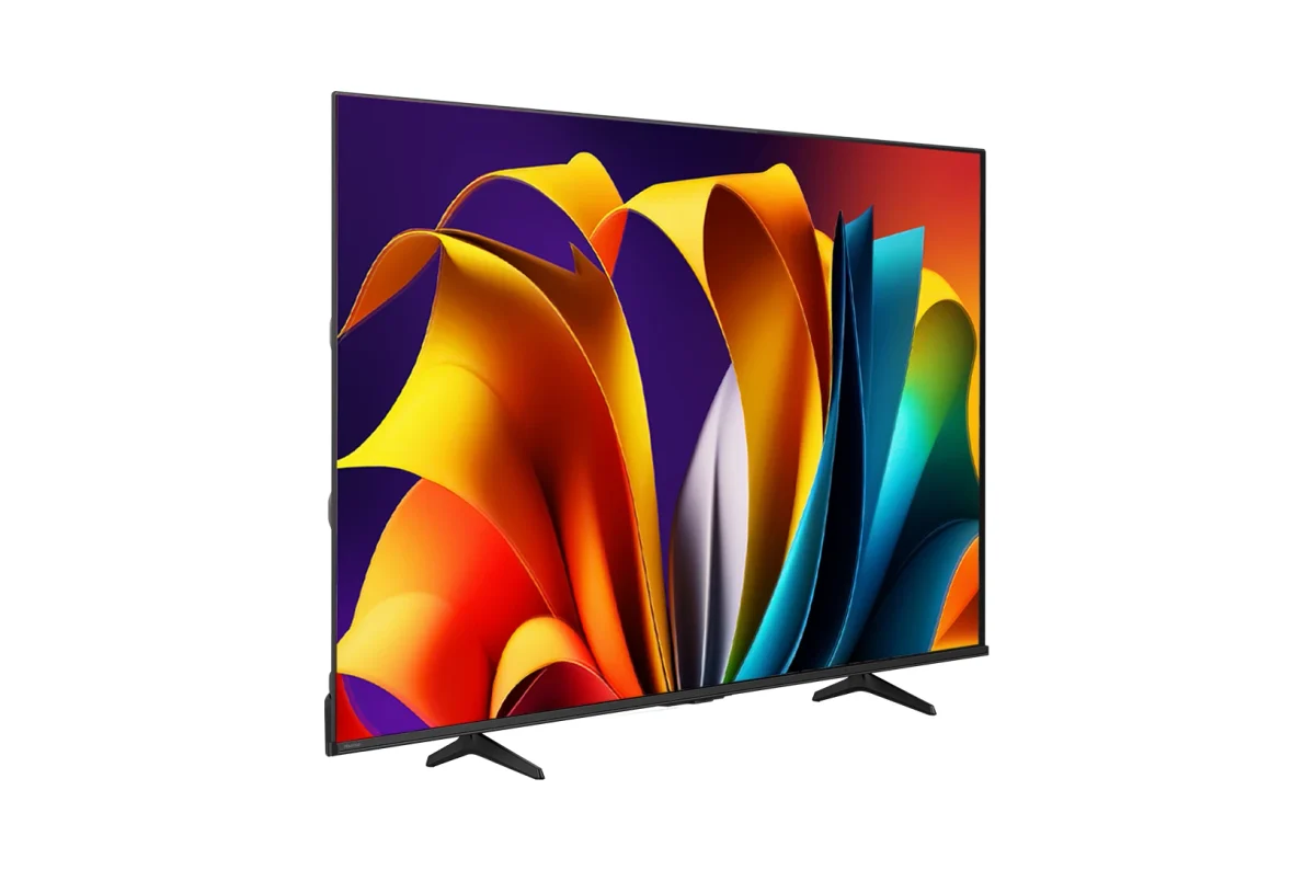 Hisense A6NV: TV de tela grande preta em ângulo lateral, com fundo cinza claro, mostrando arte colorida em amarelo, laranja, roxo e azul na tela e pés pretos em